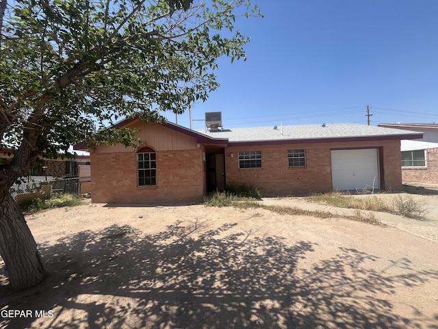 9348 Elgin Dr, El Paso, TX 79907 - view of front of property featuring brick siding, a garage, fence, dirt driveway, and central AC unit