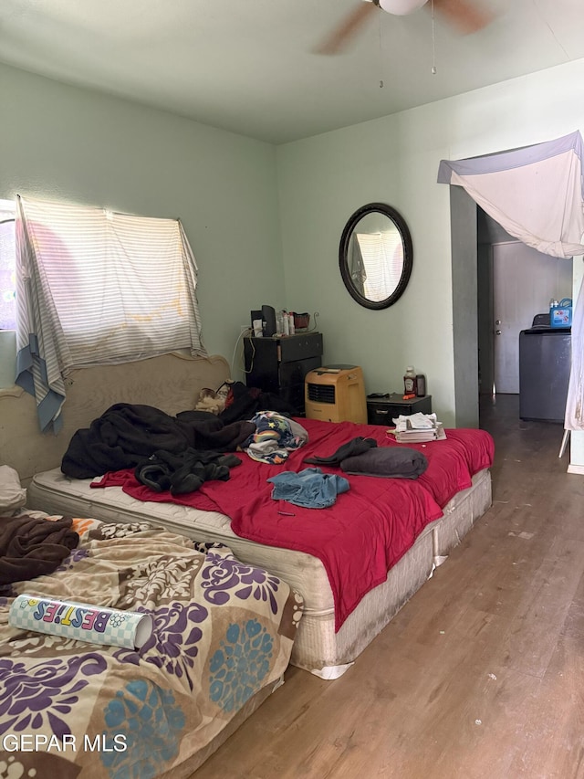 56 Palm St, El Paso, TX 79901 - bedroom featuring wood finished floors, washer / clothes dryer, and a ceiling fan