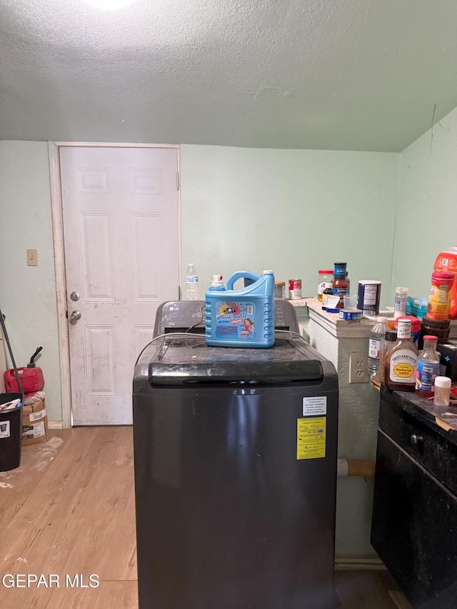56 Palm St, El Paso, TX 79901 - kitchen with light wood-style floors, washer and clothes dryer, and a textured ceiling