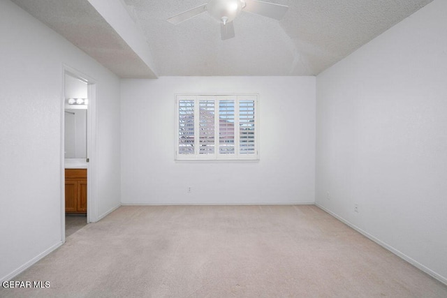 4560 Loma Canada Ct, El Paso, TX 79934 - unfurnished bedroom featuring light colored carpet, ensuite bathroom, a textured ceiling, baseboards, and ceiling fan