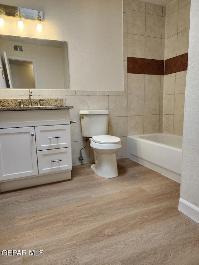 301 Bandolina Dr, Socorro, TX 79927 - bathroom with toilet, wood finished floors, vanity, and tile walls
