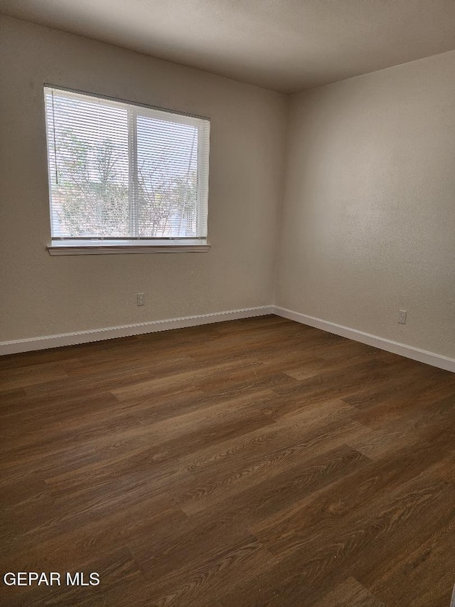 301 Bandolina Dr, Socorro, TX 79927 - spare room featuring baseboards and dark wood-style floors