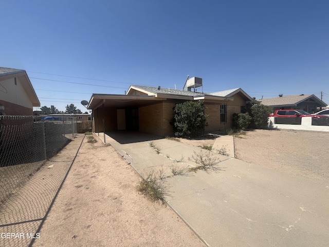 9354 Elgin Dr, El Paso, TX 79907 - view of front of house with concrete driveway, fence, a carport, and brick siding