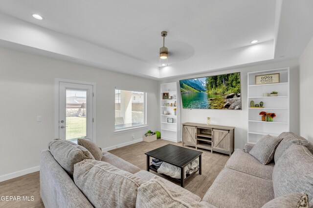 14733 Mike A Mendoza Ave, El Paso, TX 79938 - living room featuring a tray ceiling, light wood finished floors, baseboards, built in features, and recessed lighting