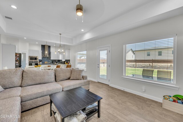 14733 Mike A Mendoza Ave, El Paso, TX 79938 - living area featuring a chandelier, light wood finished floors, baseboards, recessed lighting, and a tray ceiling