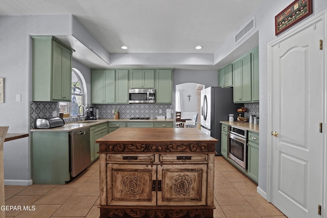 505 Canyon Springs Dr, El Paso, TX 79912 - kitchen featuring green cabinetry, appliances with stainless steel finishes, light tile patterned floors, a sink, and tasteful backsplash