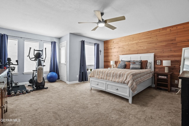 505 Canyon Springs Dr, El Paso, TX 79912 - carpeted bedroom with wooden walls, baseboards, a textured ceiling, and a ceiling fan