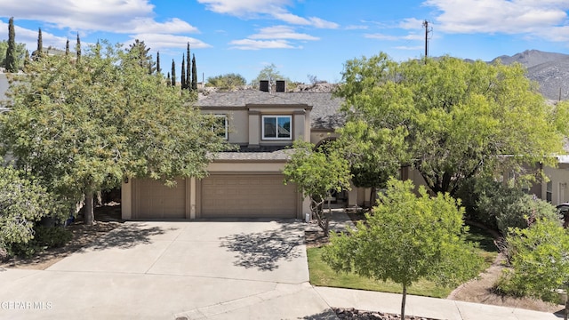 505 Canyon Springs Dr, El Paso, TX 79912 - obstructed view of property with stucco siding, concrete driveway, an attached garage, and a mountain view