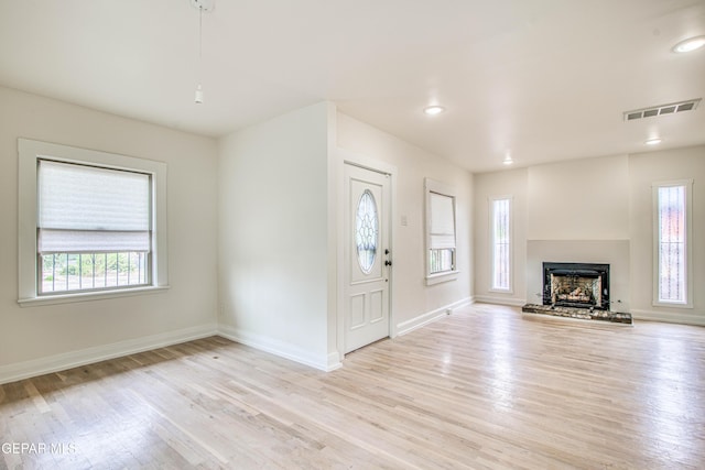 2300 N Campbell St, El Paso, TX 79902 - unfurnished living room with plenty of natural light, light wood finished floors, a fireplace with raised hearth, and recessed lighting
