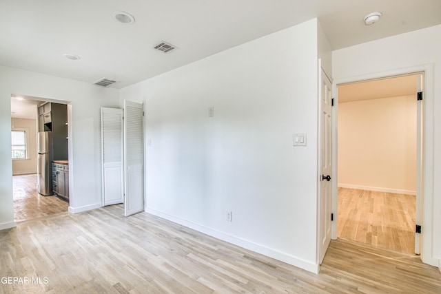 2300 N Campbell St, El Paso, TX 79902 - unfurnished bedroom featuring light wood-style flooring, ensuite bathroom, and freestanding refrigerator
