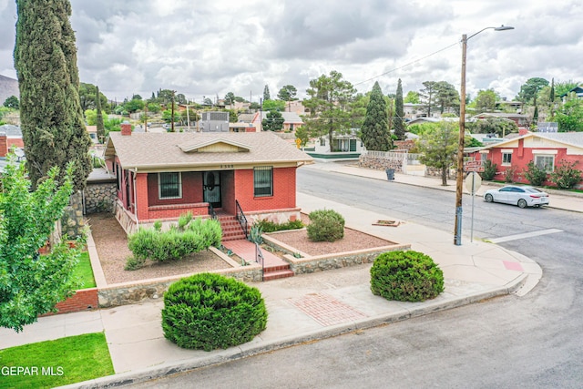 2300 N Campbell St, El Paso, TX 79902 - view of front facade with brick siding, roof with shingles, covered porch, and a residential view
