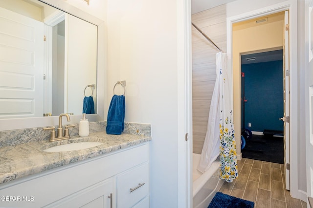7389 Cimarron Gap Dr, El Paso, TX 79911 - bathroom with vanity, wood finish floors, and shower / tub combo