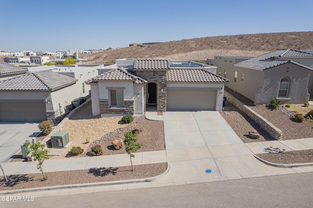 7389 Cimarron Gap Dr, El Paso, TX 79911 - mediterranean / spanish home featuring a garage, a tile roof, stucco siding, concrete driveway, and stone siding