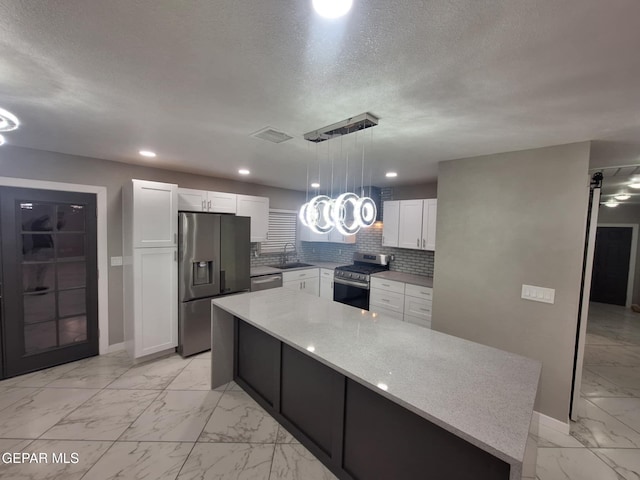 11574 La Poblana Dr, Socorro, TX 79927 - kitchen featuring appliances with stainless steel finishes, a sink, light marble finish flooring, white cabinetry, and baseboards