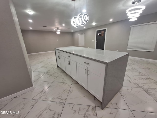 11574 La Poblana Dr, Socorro, TX 79927 - kitchen with light marble finish floors, baseboards, a ceiling fan, recessed lighting, and a center island