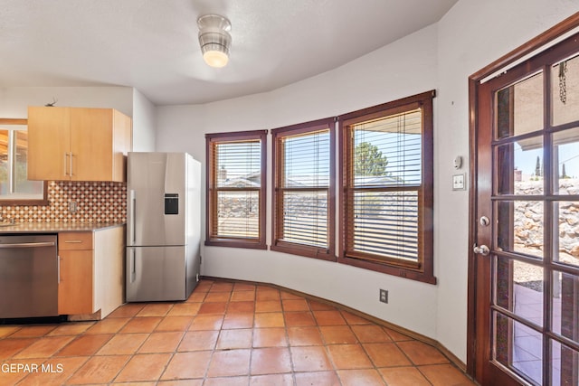 903 Agua Caliente Dr, El Paso, TX 79912 - kitchen featuring appliances with stainless steel finishes, backsplash, light brown cabinetry, light tile patterned flooring, and baseboards