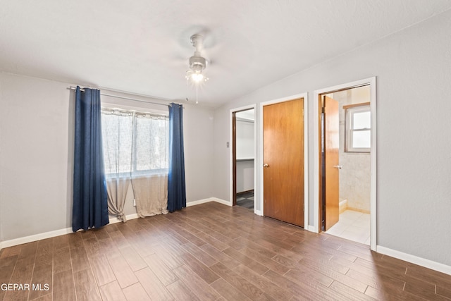 903 Agua Caliente Dr, El Paso, TX 79912 - unfurnished bedroom featuring multiple windows, wood finished floors, baseboards, and ensuite bath