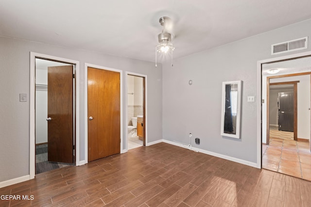 903 Agua Caliente Dr, El Paso, TX 79912 - unfurnished bedroom featuring wood finished floors, baseboards, and connected bathroom
