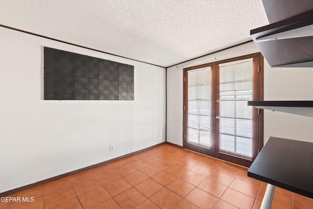 903 Agua Caliente Dr, El Paso, TX 79912 - spare room with french doors, a textured ceiling, and tile patterned flooring