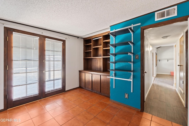 903 Agua Caliente Dr, El Paso, TX 79912 - unfurnished room with french doors, a textured ceiling, and baseboards