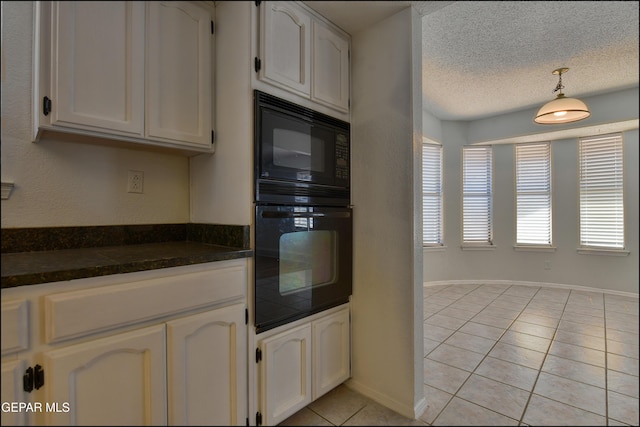 4372 Loma De Oro Dr, El Paso, TX 79934 - kitchen with dark countertops, light tile patterned floors, white cabinetry, hanging light fixtures, and black microwave