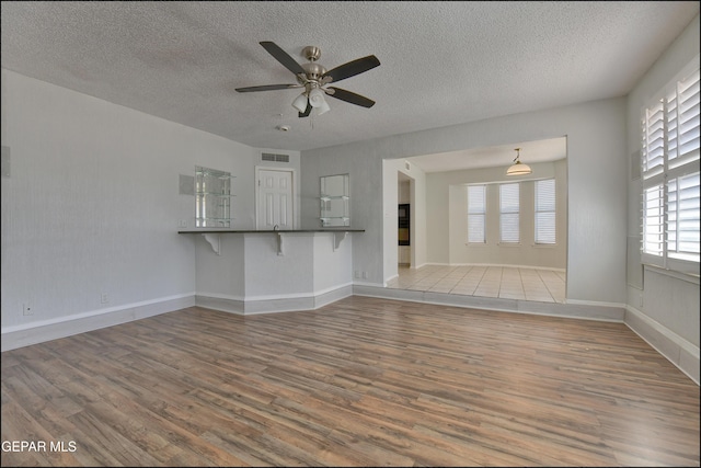 4372 Loma De Oro Dr, El Paso, TX 79934 - unfurnished living room featuring wood finished floors, a ceiling fan, a textured ceiling, and baseboards