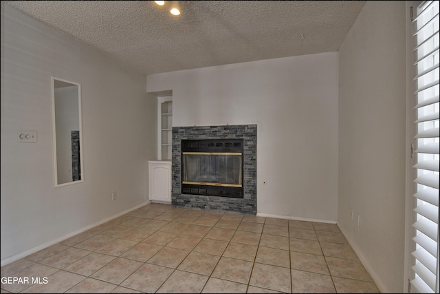 4372 Loma De Oro Dr, El Paso, TX 79934 - unfurnished living room with light tile patterned floors, a glass covered fireplace, a textured ceiling, and baseboards