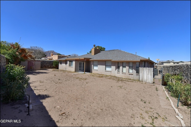 4372 Loma De Oro Dr, El Paso, TX 79934 - rear view of property featuring brick siding, a fenced backyard, and a chimney