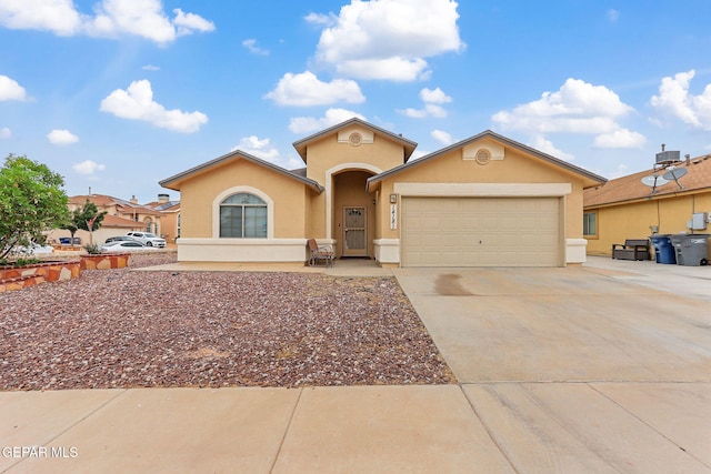 14181 Rudy Valdez Dr, El Paso, TX 79938 - view of front facade with stucco siding, an attached garage, and concrete driveway