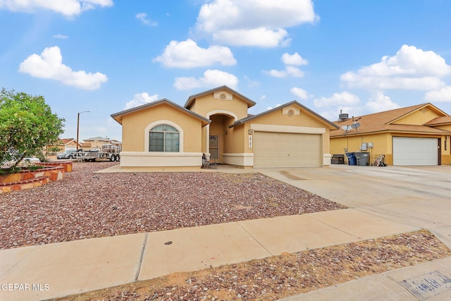 14181 Rudy Valdez Dr, El Paso, TX 79938 - view of front of house with a garage, driveway, and stucco siding