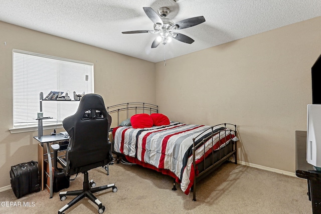 14181 Rudy Valdez Dr, El Paso, TX 79938 - carpeted bedroom with multiple windows, a ceiling fan, baseboards, and a textured ceiling