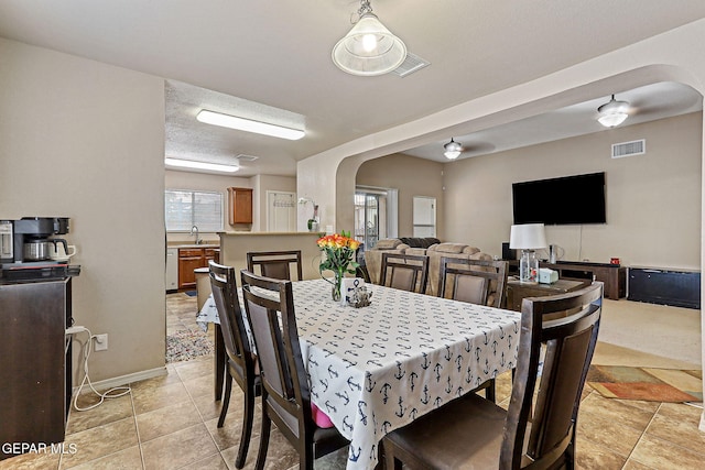 14181 Rudy Valdez Dr, El Paso, TX 79938 - dining room with arched walkways, light tile patterned floors, and baseboards