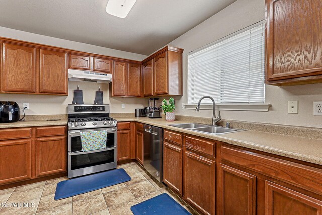 14181 Rudy Valdez Dr, El Paso, TX 79938 - kitchen featuring appliances with stainless steel finishes, under cabinet range hood, a sink, and light countertops