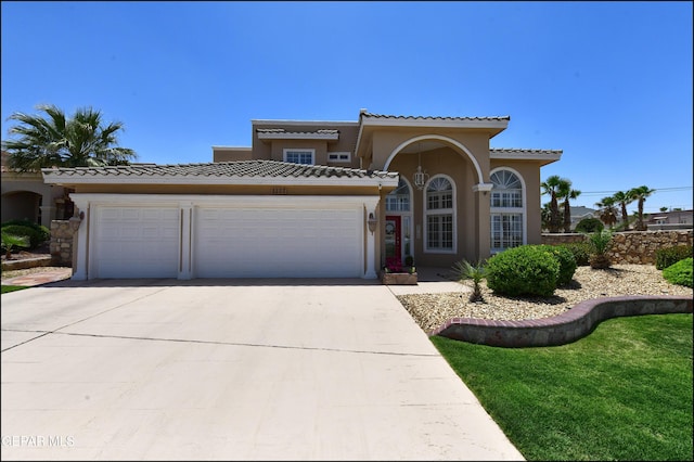 1337 Emerald Gate Ln, El Paso, TX 79936 - mediterranean / spanish-style home with stucco siding, a tile roof, driveway, and an attached garage