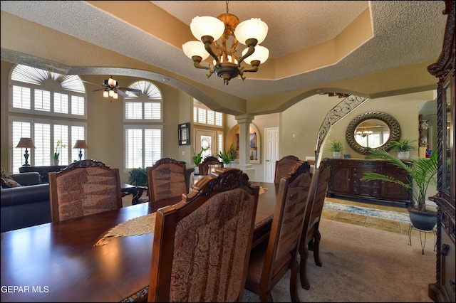 1337 Emerald Gate Ln, El Paso, TX 79936 - carpeted dining space with arched walkways, a chandelier, ornate columns, a textured ceiling, and a ceiling fan