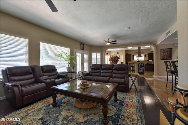 1337 Emerald Gate Ln, El Paso, TX 79936 - living room with a ceiling fan, arched walkways, a textured ceiling, baseboards, and wood finished floors