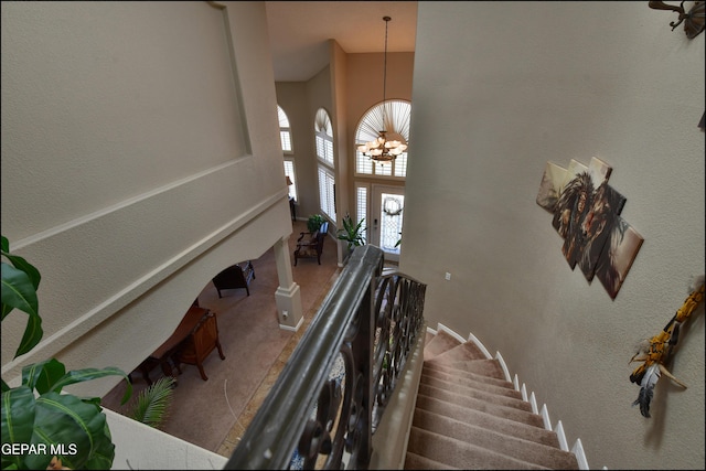 1337 Emerald Gate Ln, El Paso, TX 79936 - staircase with a high ceiling, carpet flooring, a chandelier, and a textured wall