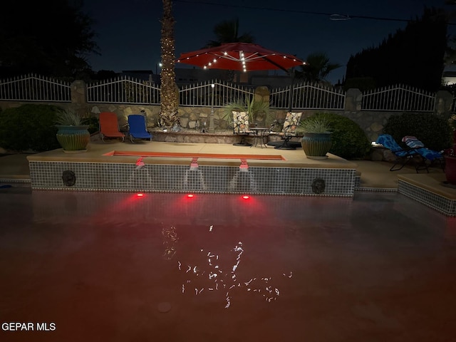1337 Emerald Gate Ln, El Paso, TX 79936 - pool at night with a patio area
