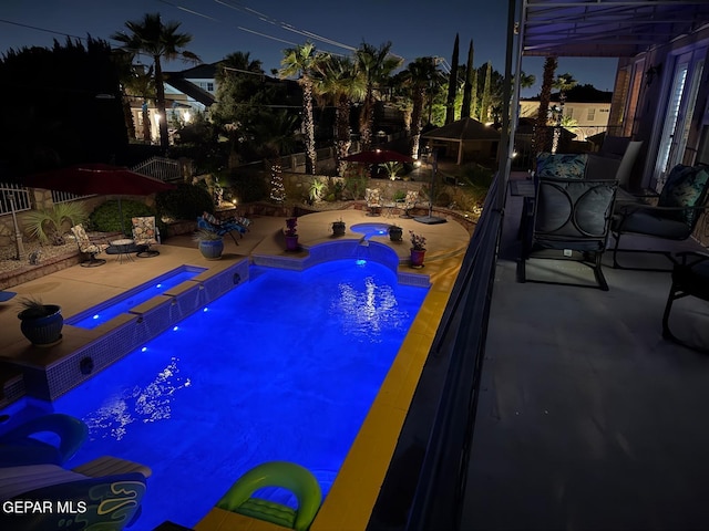 1337 Emerald Gate Ln, El Paso, TX 79936 - pool at night with an in-ground hot tub, a patio, a fenced backyard, and outdoor dining space