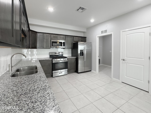 11500 Summer Dr Unit A & B, Socorro, TX 79927 - kitchen with stainless steel appliances, a sink, light stone counters, backsplash, and light tile patterned floors
