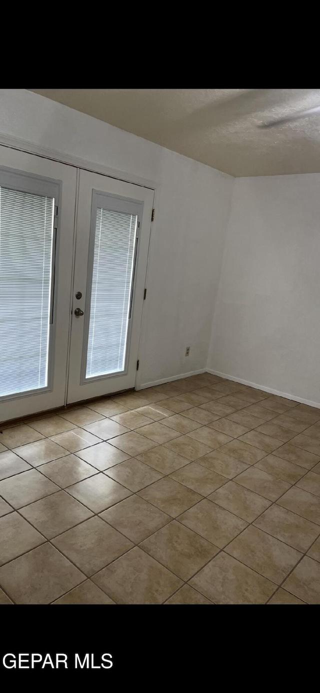 1017 Ralpheene St, El Paso, TX 79907 - empty room with french doors, light tile patterned floors, and baseboards