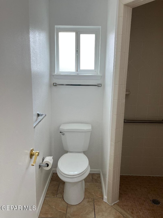 1017 Ralpheene St, El Paso, TX 79907 - bathroom featuring toilet, tile patterned floors, baseboards, and tiled shower