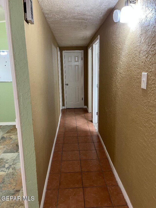 1017 Ralpheene St, El Paso, TX 79907 - hall with a textured wall, a textured ceiling, baseboards, and tile patterned flooring