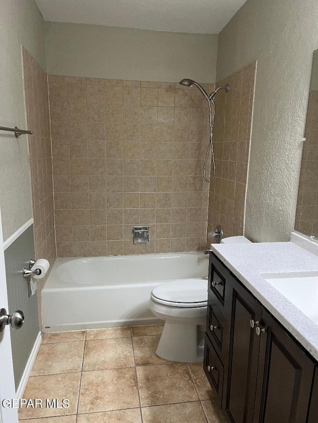 1017 Ralpheene St, El Paso, TX 79907 - bathroom featuring a textured wall, vanity, toilet, washtub / shower combination, and tile patterned floors
