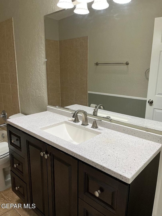 1017 Ralpheene St, El Paso, TX 79907 - bathroom with a textured wall, toilet, vanity, and tub / shower combination
