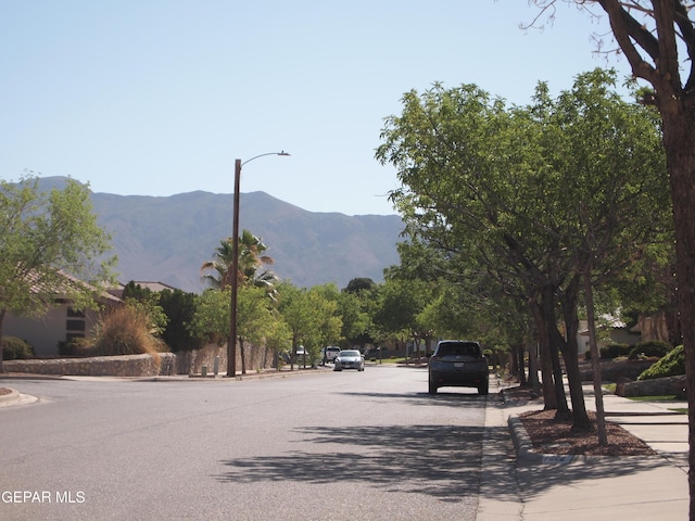 7012 Diamond Ridge Dr, El Paso, TX 79912 - view of asphalt street featuring curbs, sidewalks, a mountain view, and street lighting