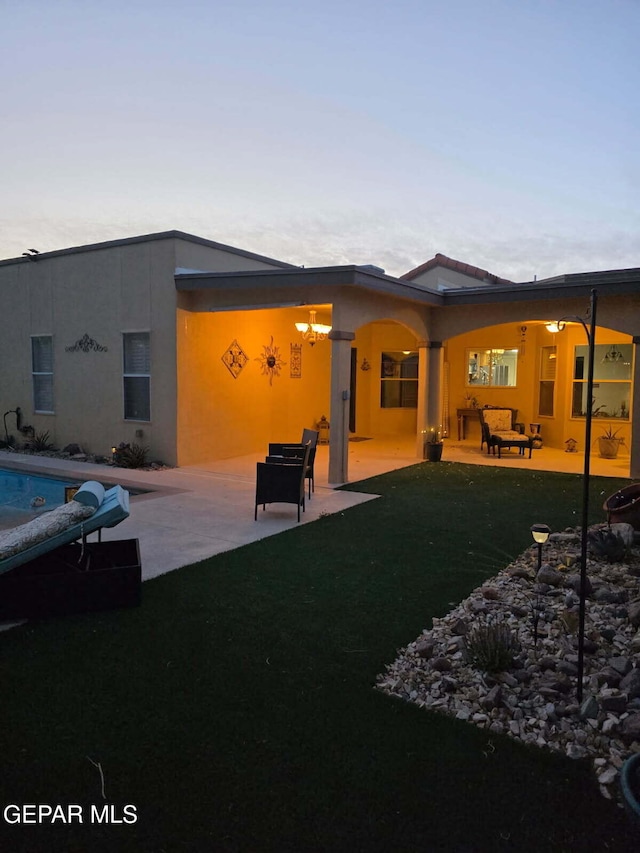 7012 Diamond Ridge Dr, El Paso, TX 79912 - rear view of house featuring a patio area, stucco siding, a lawn, and an outdoor pool