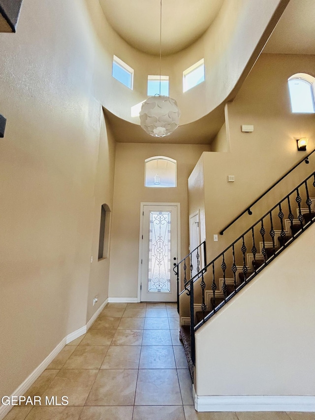 11609 Saint Thomas Way, El Paso, TX 79936 - foyer entrance featuring a towering ceiling, baseboards, light tile patterned floors, and stairway