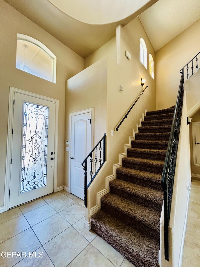 11609 Saint Thomas Way, El Paso, TX 79936 - foyer entrance with a towering ceiling, plenty of natural light, stairs, light tile patterned flooring, and baseboards