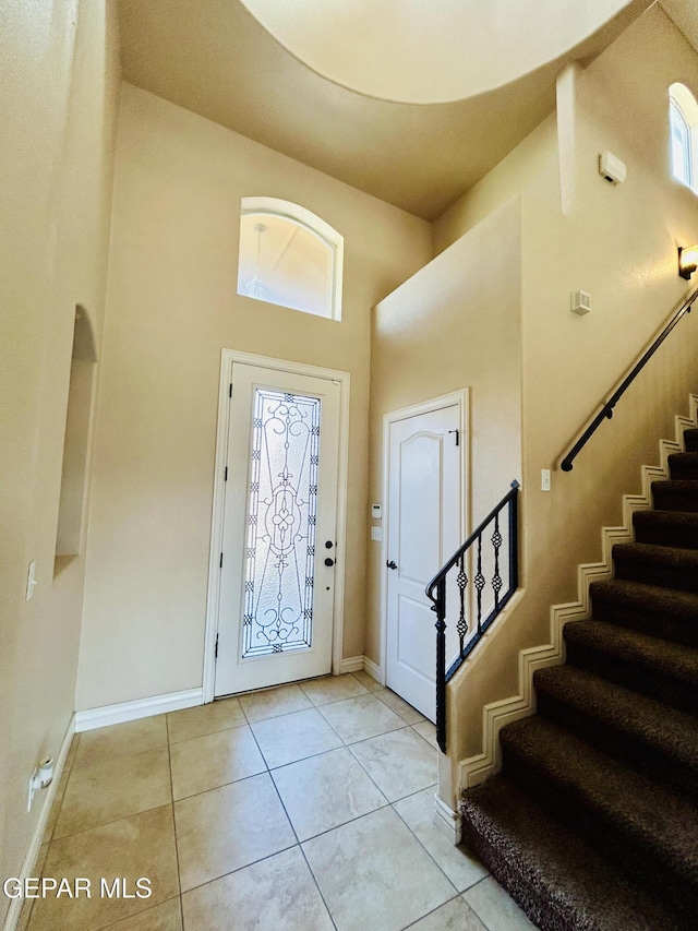 11609 Saint Thomas Way, El Paso, TX 79936 - entryway featuring a towering ceiling, stairs, plenty of natural light, baseboards, and light tile patterned floors